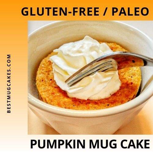 Gluten-free/paleo pumpkin mug cake with whipped cream on top and a fork about to take a bite