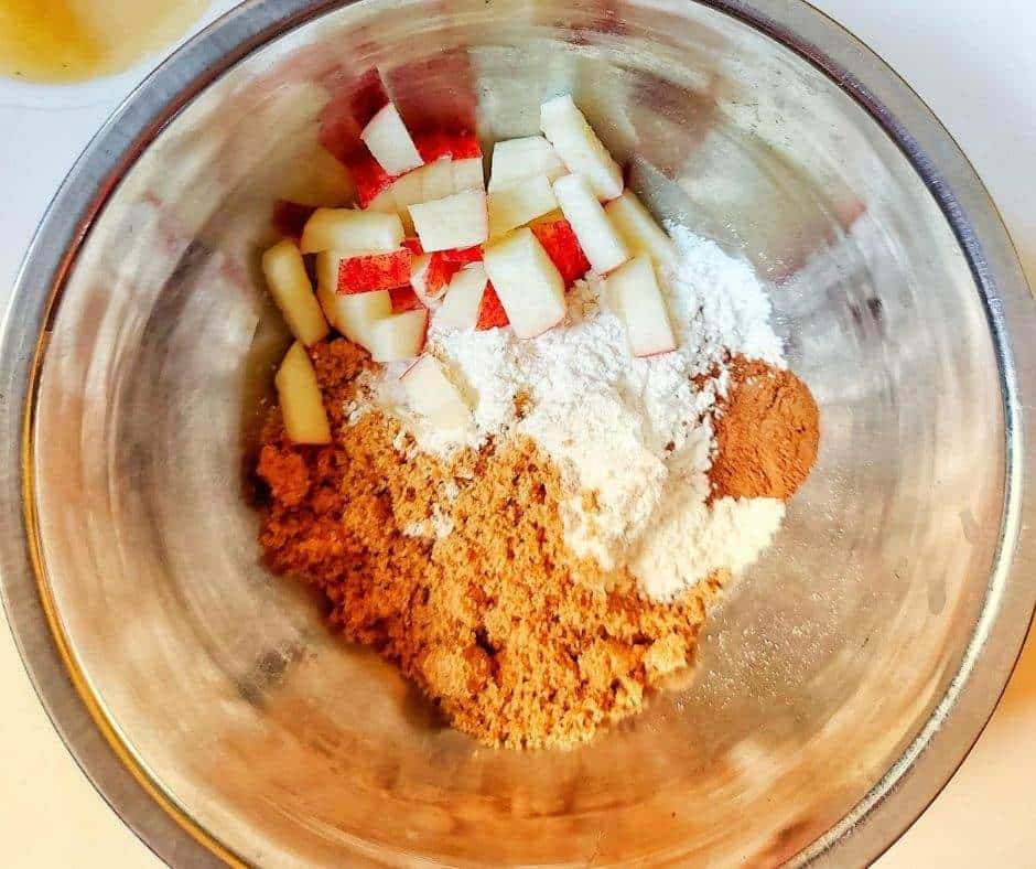 Metal bowl with flour, apples, cinnamon, brown sugar