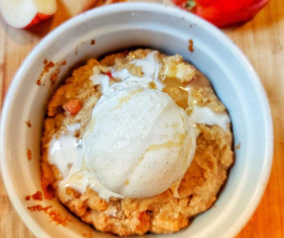 Apple mug cake with ice cream and caramel sauce