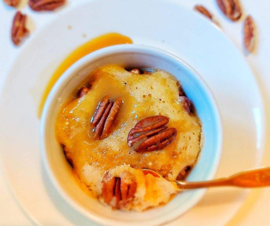 This pecan butterscotch mug cake is like having your favorite pecan pie, without any of the fussy pie-crust-making. Sweet butterscotch and crunchy pecans will make this 1-minute mug cake your new favorite quick snack! | thanksgiving desserts, fall desserts, pecan pie, pecan mug cake, butterscotch, caramel mug cake, easy snacks, microwave desserts, microwave recipes