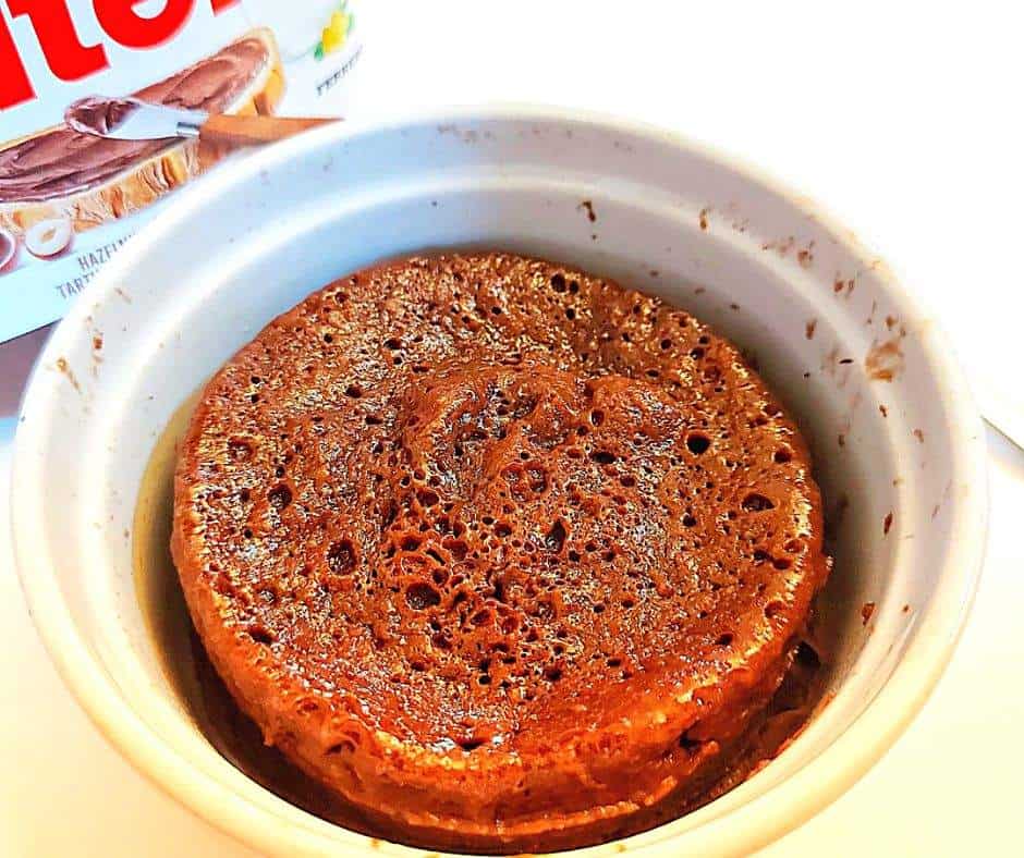 Nutella mug cake with a jar of Nutella chocolate hazelnut spread in the background
