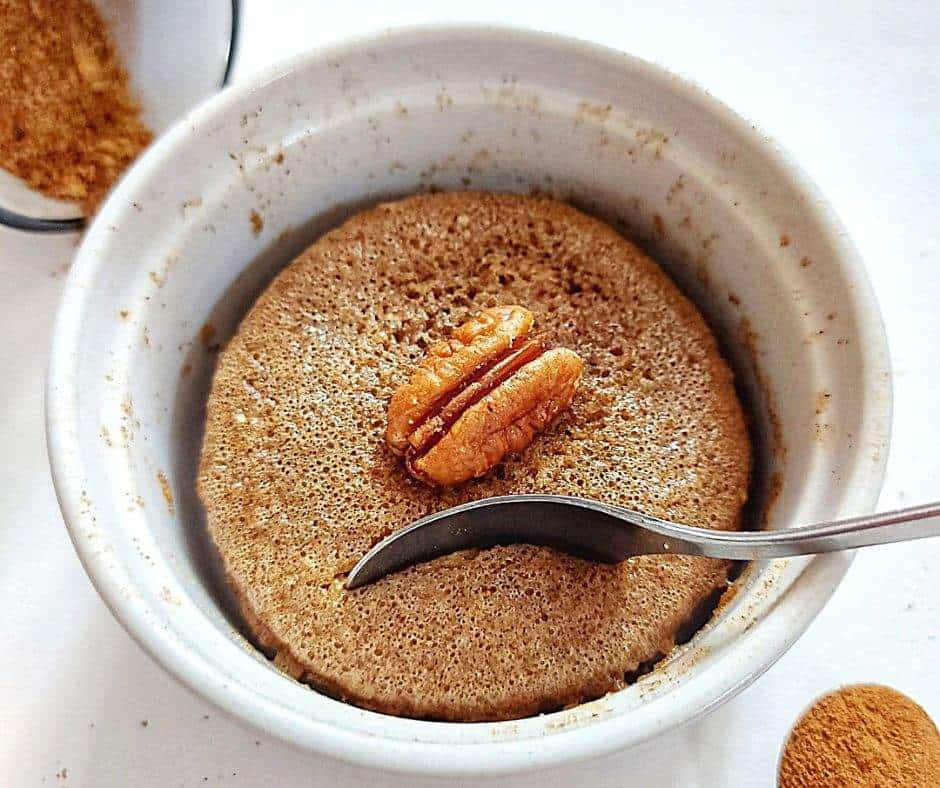 Cinnamon mug cake with pecans and a spoon
