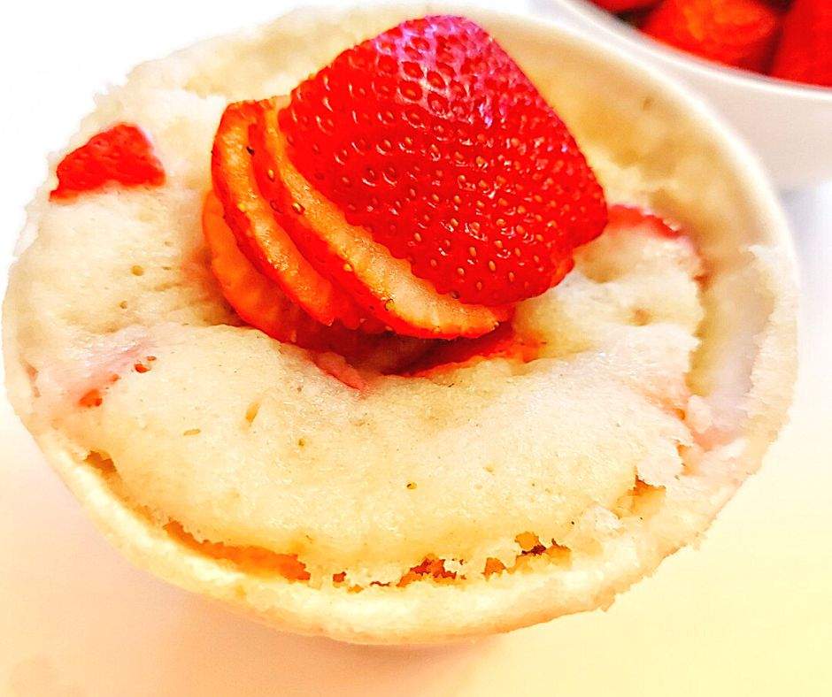 Strawberry mug cake topped with slice strawberries